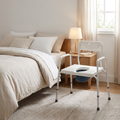 3-in-1 bedside commode beside a bed in a bright bedroom